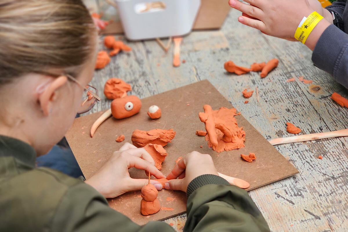 Kinderen zitten te kleien aan een tafel.
