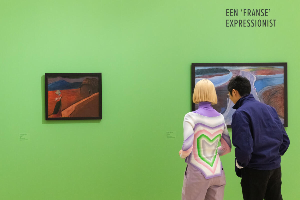 Zwei junge Besucher stehen vor einer leuchtend gr&uuml;nen Wand. An der Wand h&auml;ngen zwei Gem&auml;lde.