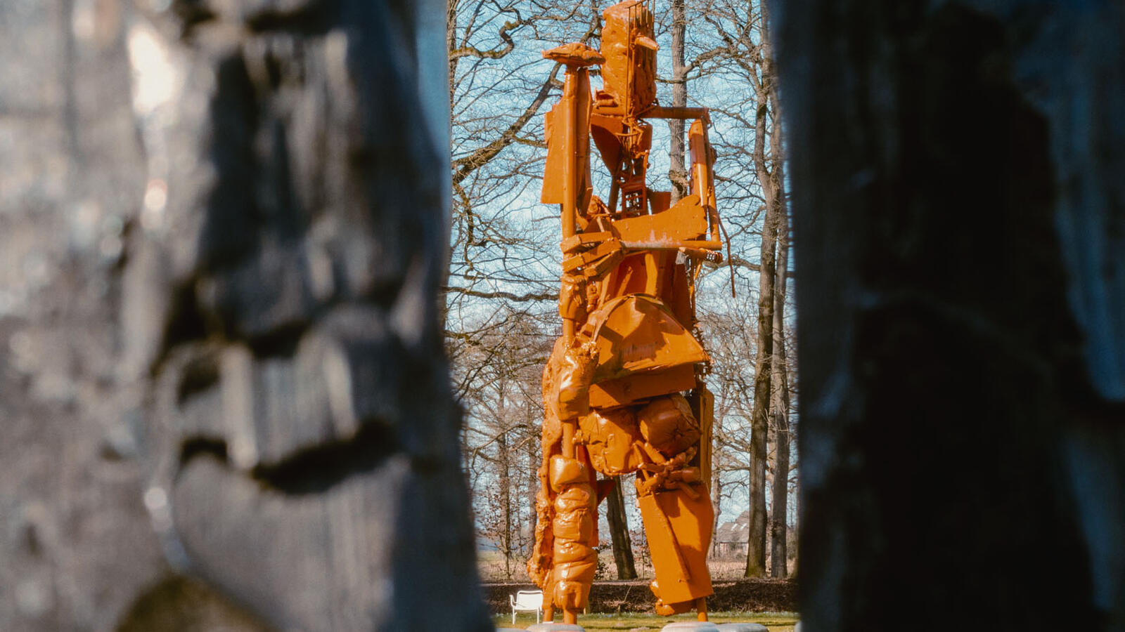 Een abstract metalen sculptuur is zichtbaar tussen twee rotsblokken in.