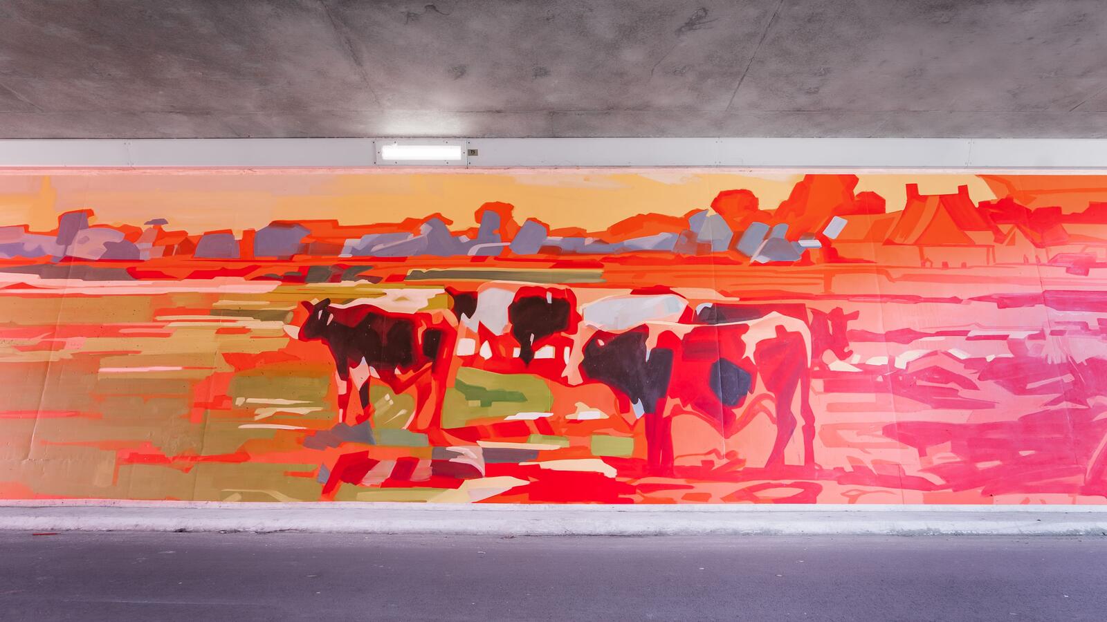 Een muurschildering van koeien in een wei, met veel rode kleur en kleurcontrast.