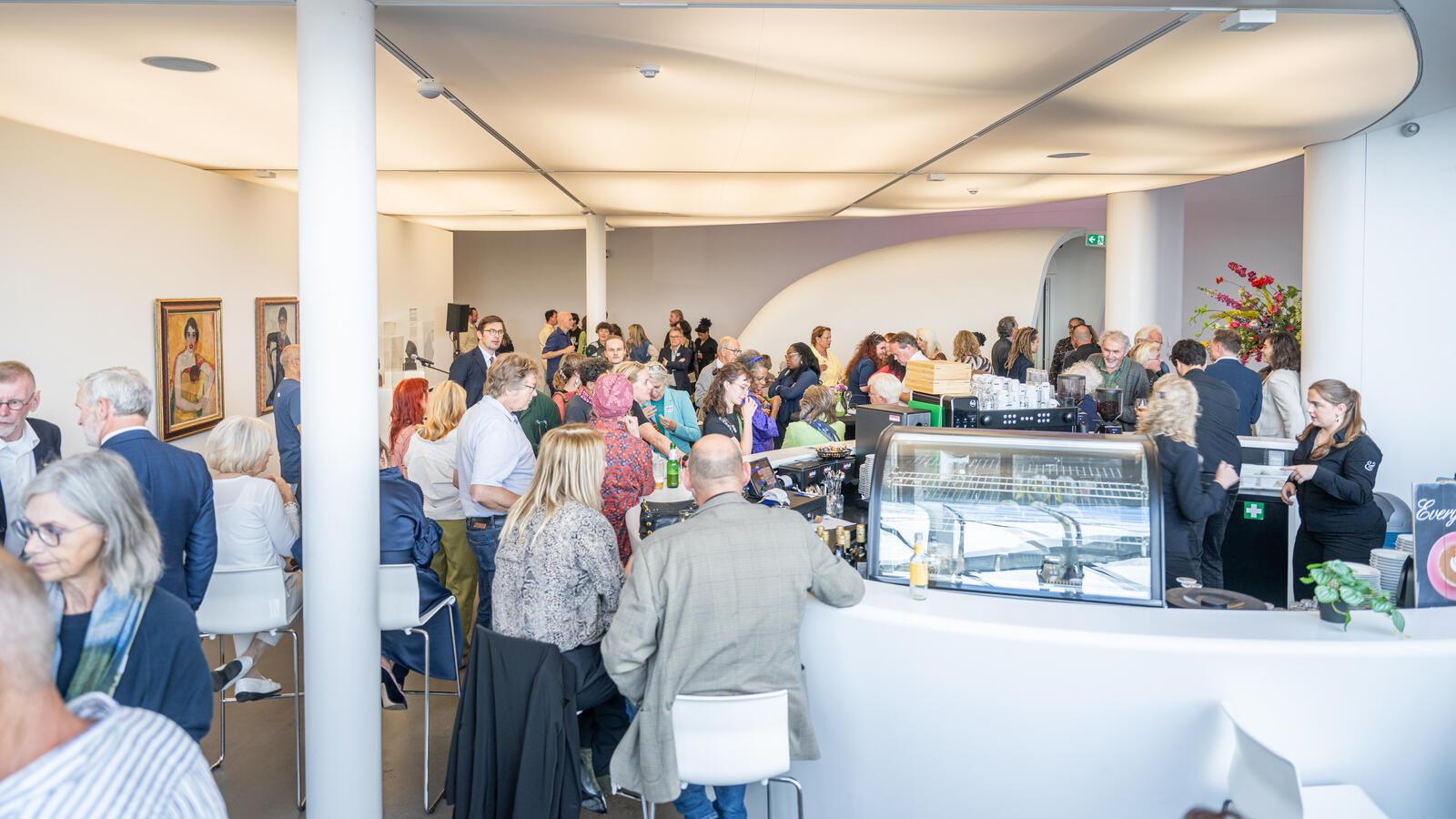 Ein &uuml;berf&uuml;llter Raum im Museum de Fundatie mit sitzenden und stehenden Menschen f&uuml;r eine Veranstaltung.