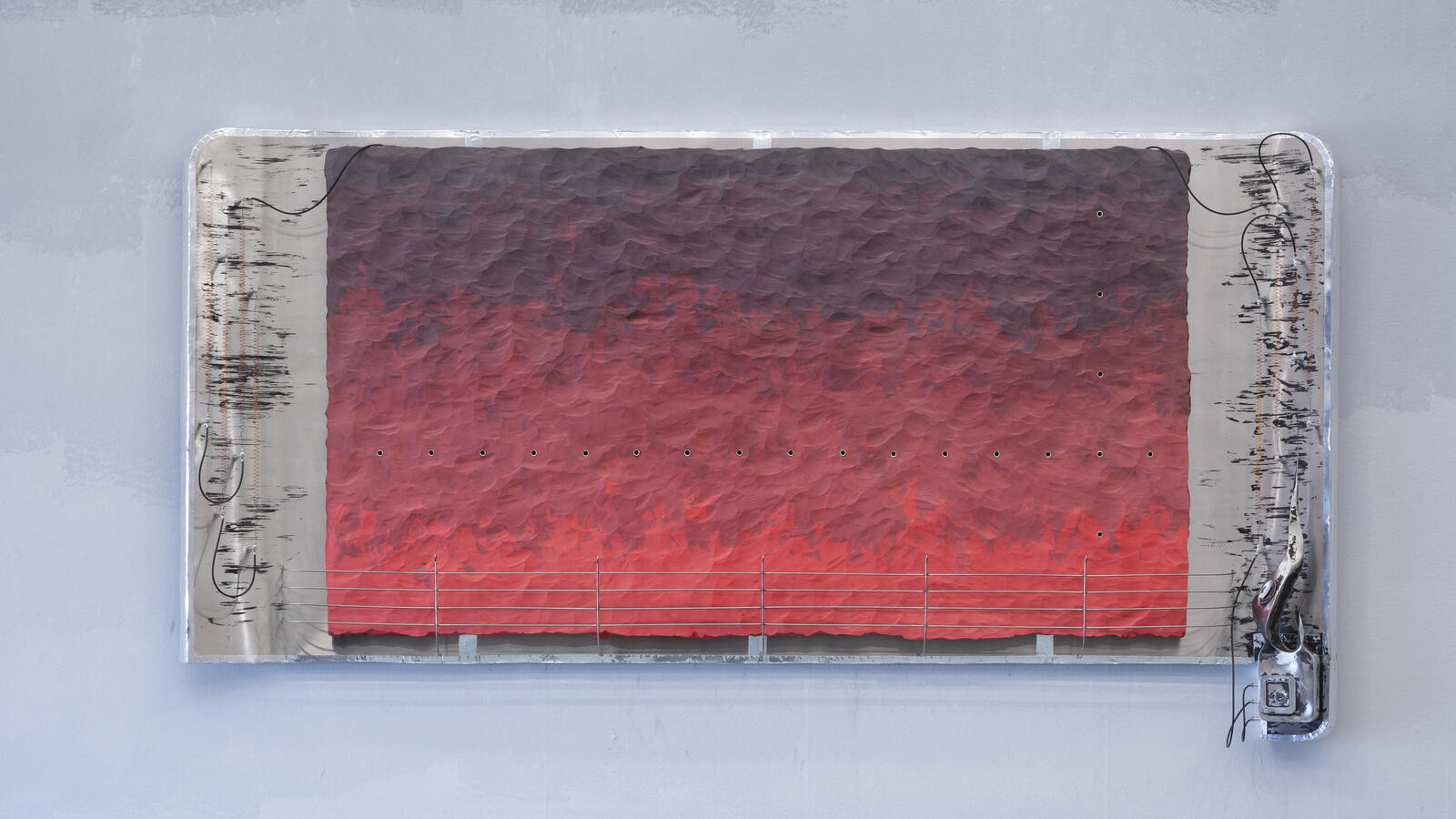een kunstwerk dat op een witte muur hangt. het kunstwerk is horizontaal en is erg abstract, het bevat vooral de rode kleur in verschillende tinten.