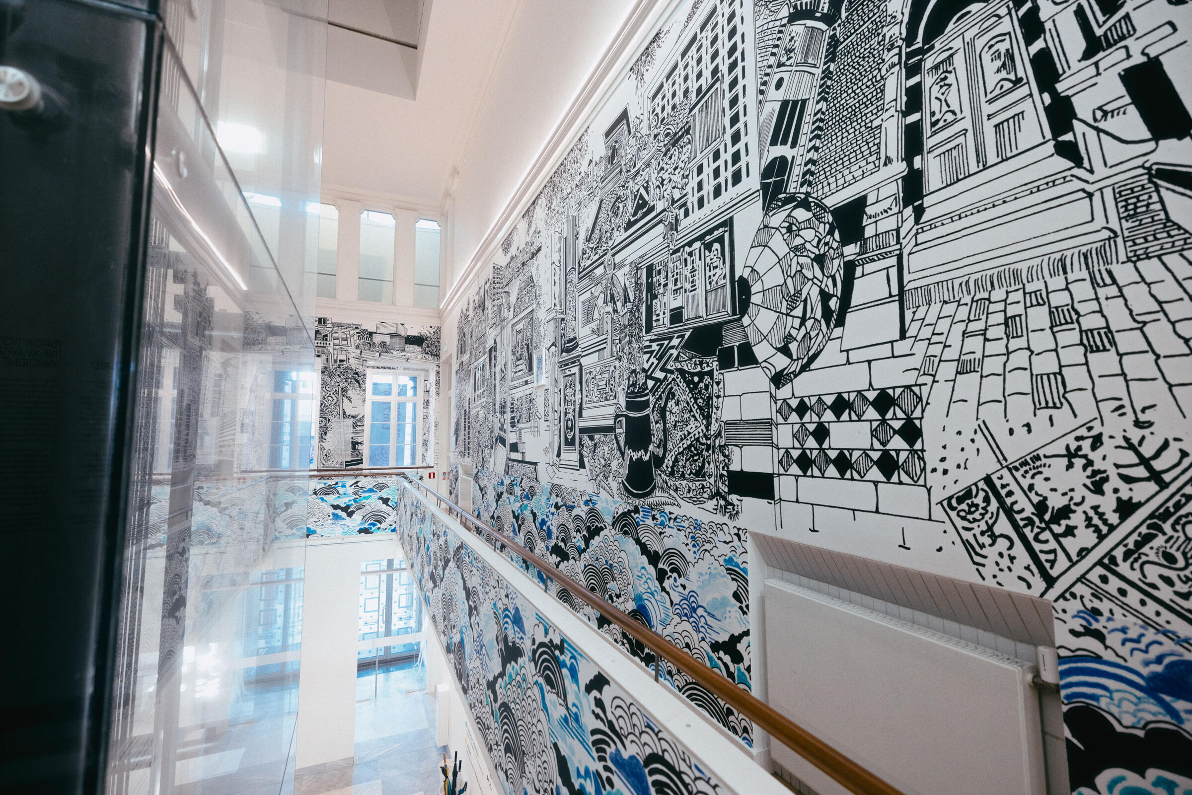 De balustrade van de Fundatie, met rechts een grote muur illustratie in zwart-wit en blauw