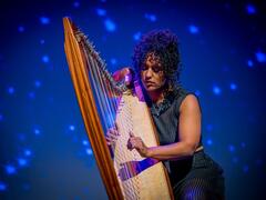 Indra Diallo speelt de harp. 